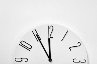 Photo of Stylish analog clock hanging on white wall, space for text. New Year countdown