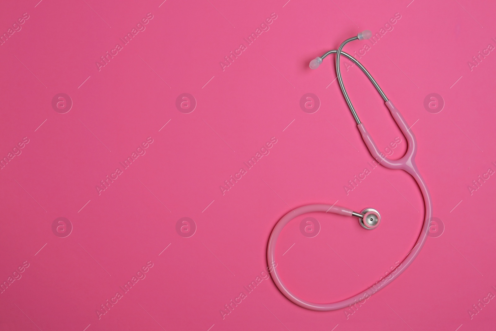 Photo of Modern stethoscope on pink background, top view. Space for text