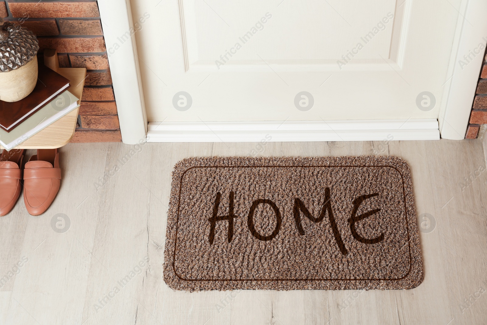 Image of Door mat with word Home on wooden floor in hall, above view