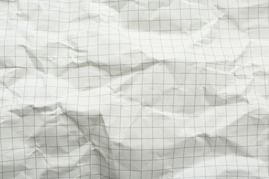 Crumpled checkered notebook sheet as background, top view