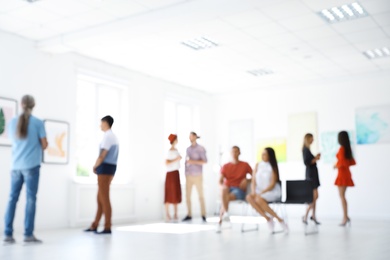 Photo of Blurred view of people at exhibition in art gallery