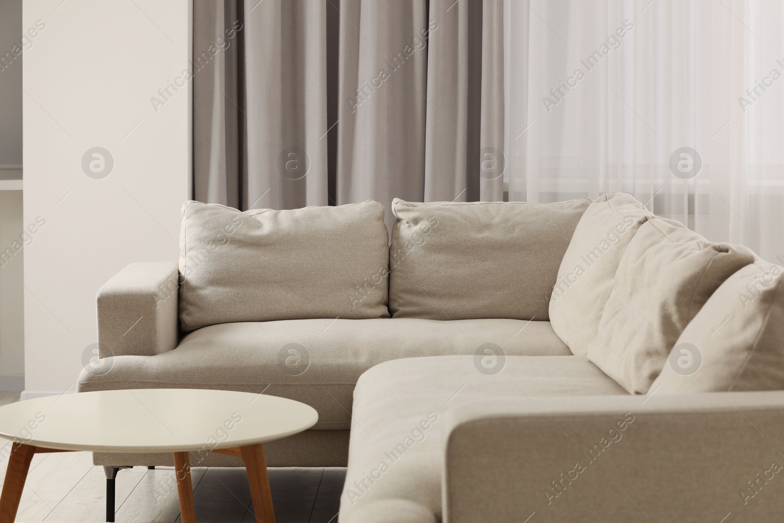 Photo of Stylish living room interior with comfortable sofa and side table