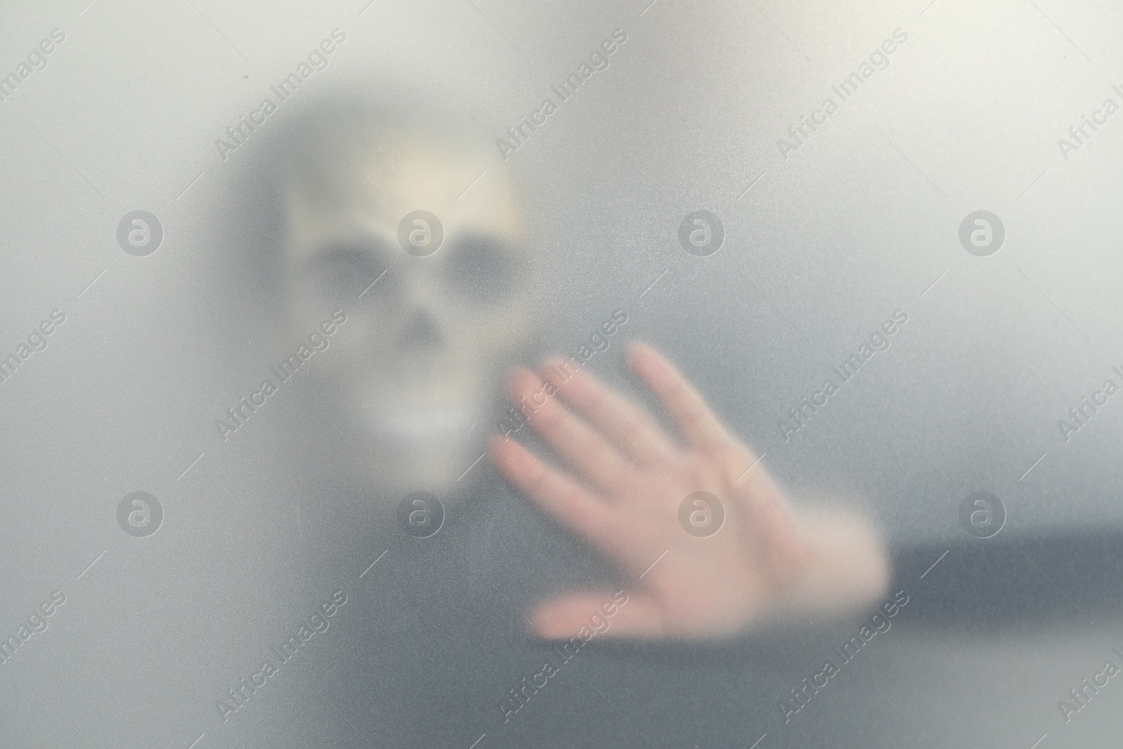 Photo of Silhouette of creepy ghost with skull behind cloth