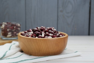 Photo of Bowl with dry kidney beans on white table