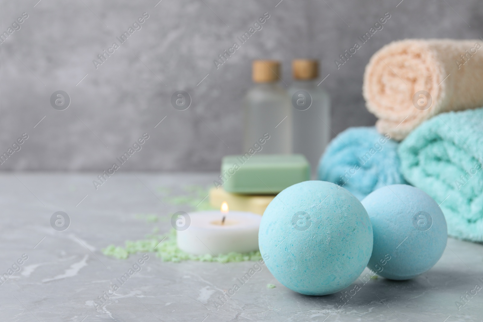 Photo of Beautiful aromatic bath bombs on light grey table, space for text