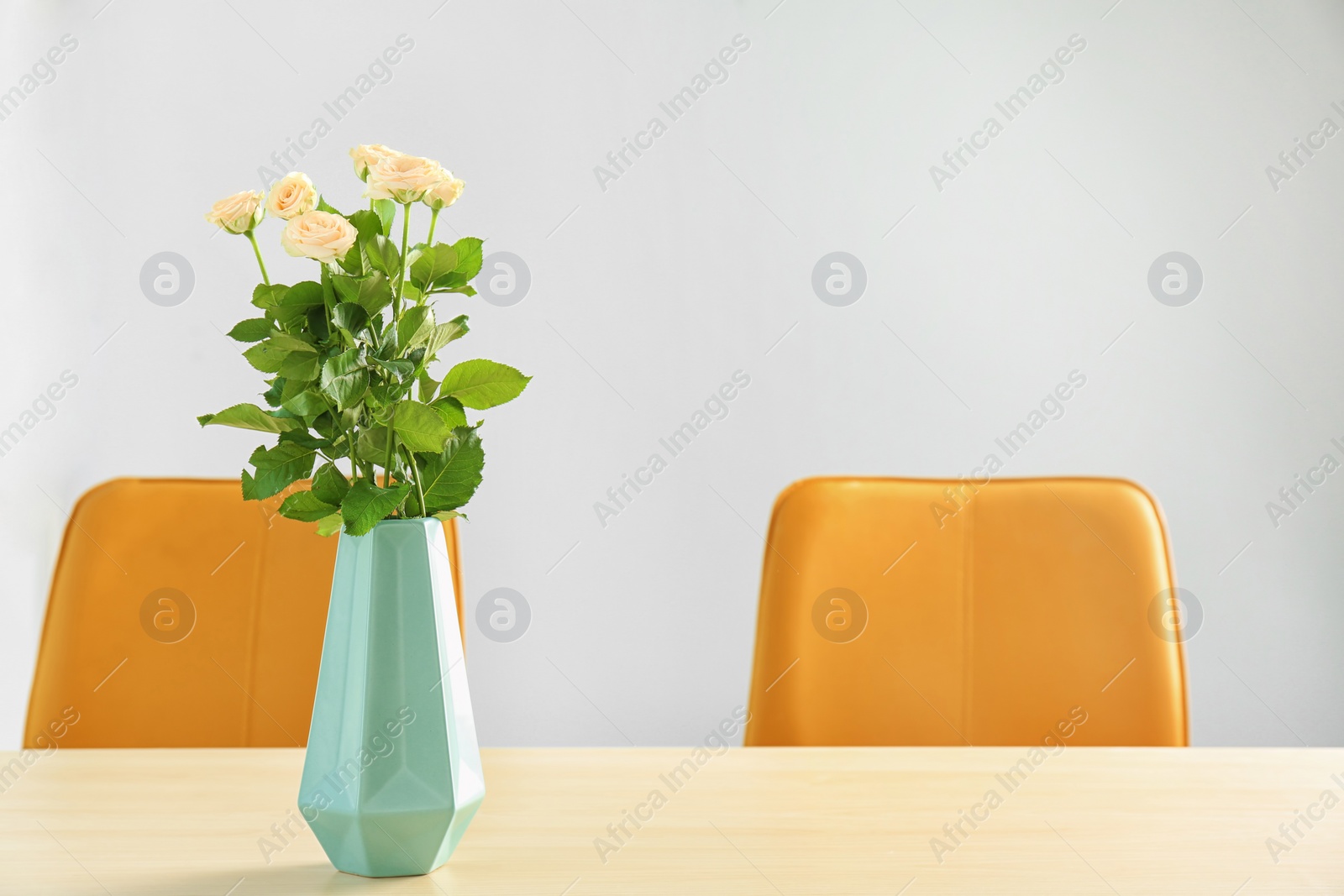 Photo of Vase with blooming flowers on table indoors