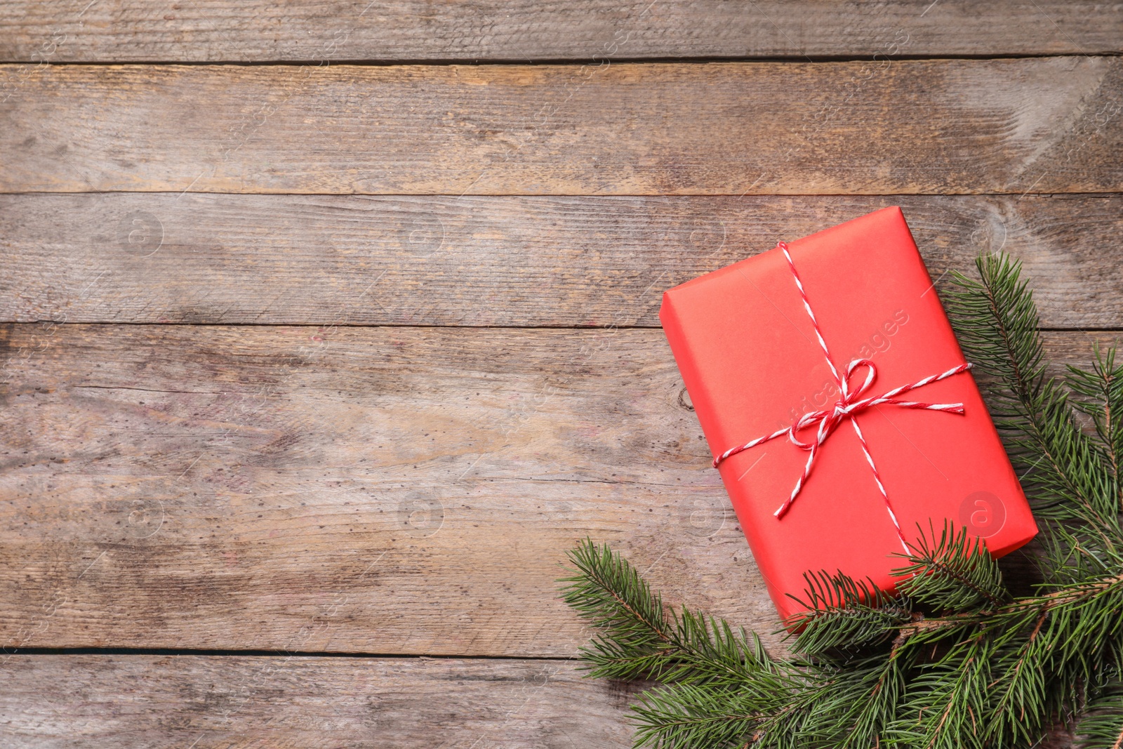 Photo of Beautiful Christmas gift box and fir tree branch on wooden background, top view