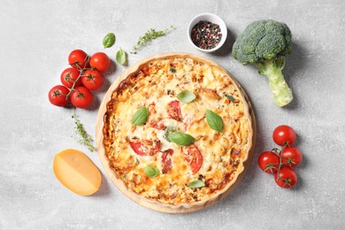 Photo of Flat lay composition of tasty quiche with tomatoes, basil and cheese served on light table