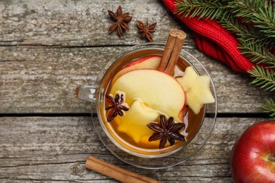 Hot mulled cider and ingredients on wooden table, flat lay