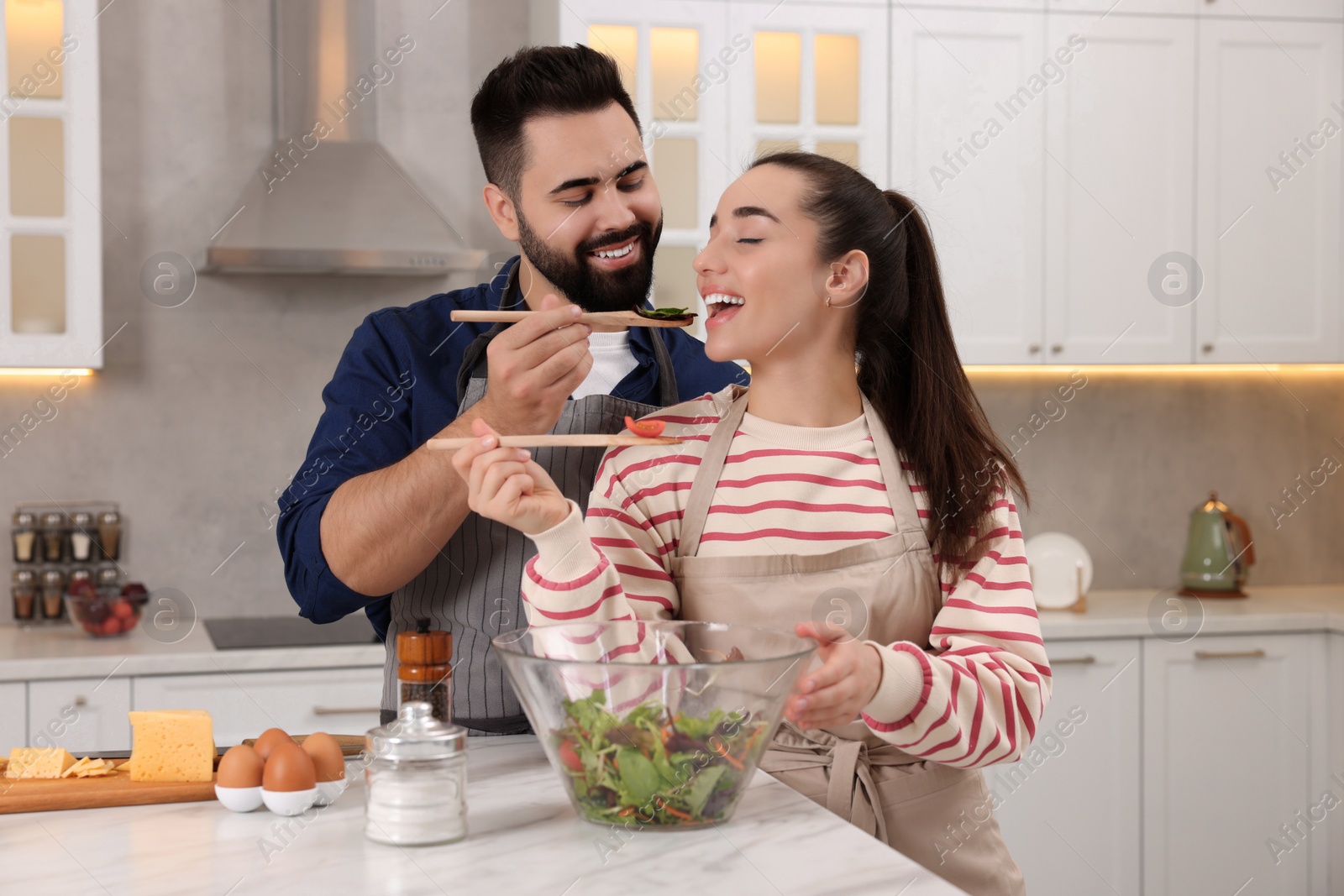 Photo of Happy lovely couple cooking together in kitchen