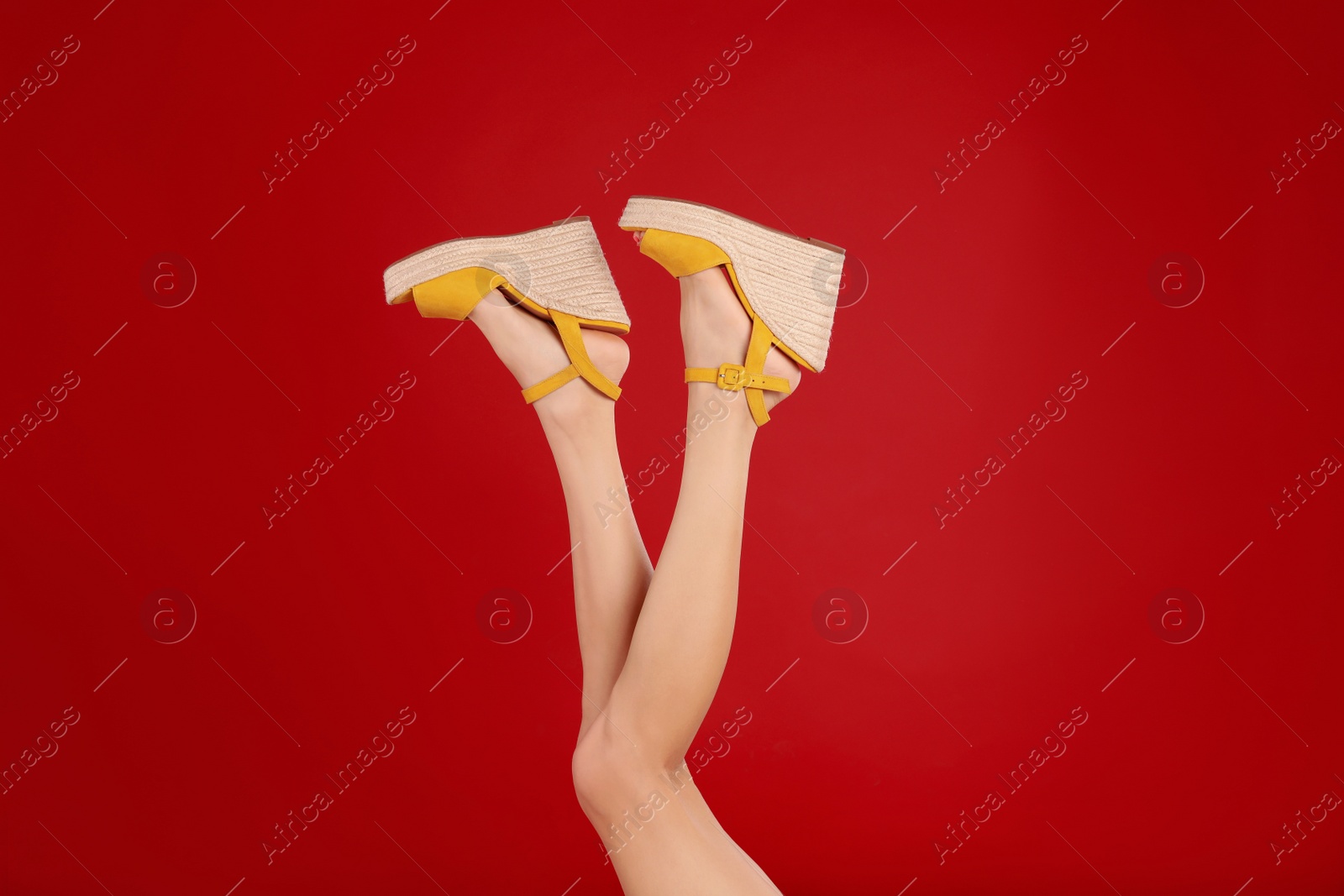 Photo of Woman in stylish shoes on red background