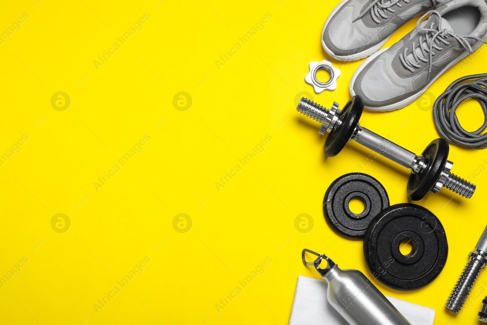 Gym equipment on yellow background, flat lay. Space for text Photo of Gym equipment on yellow background, flat lay. Space for text
