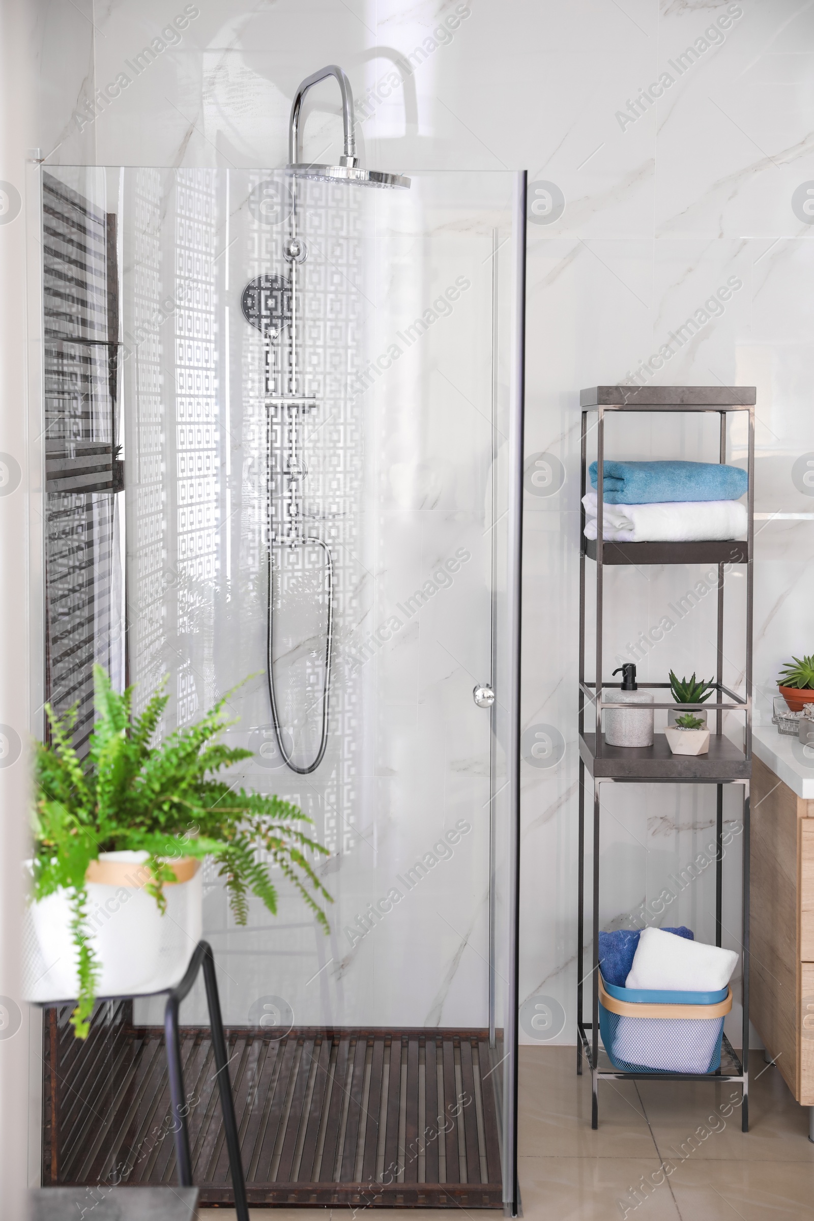 Photo of Bathroom interior with shower stall and shelving unit. Idea for design