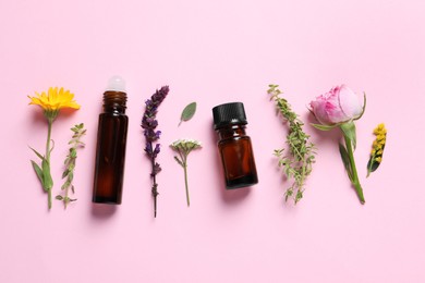 Photo of Bottles of essential oils, different herbs and flowers on pink background, flat lay