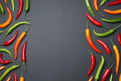 Photo of Frame made with different chili peppers on black background, flat lay. Space for text