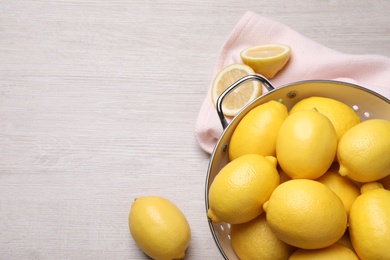 Photo of Many fresh ripe lemons on wooden table, flat lay. Space for text