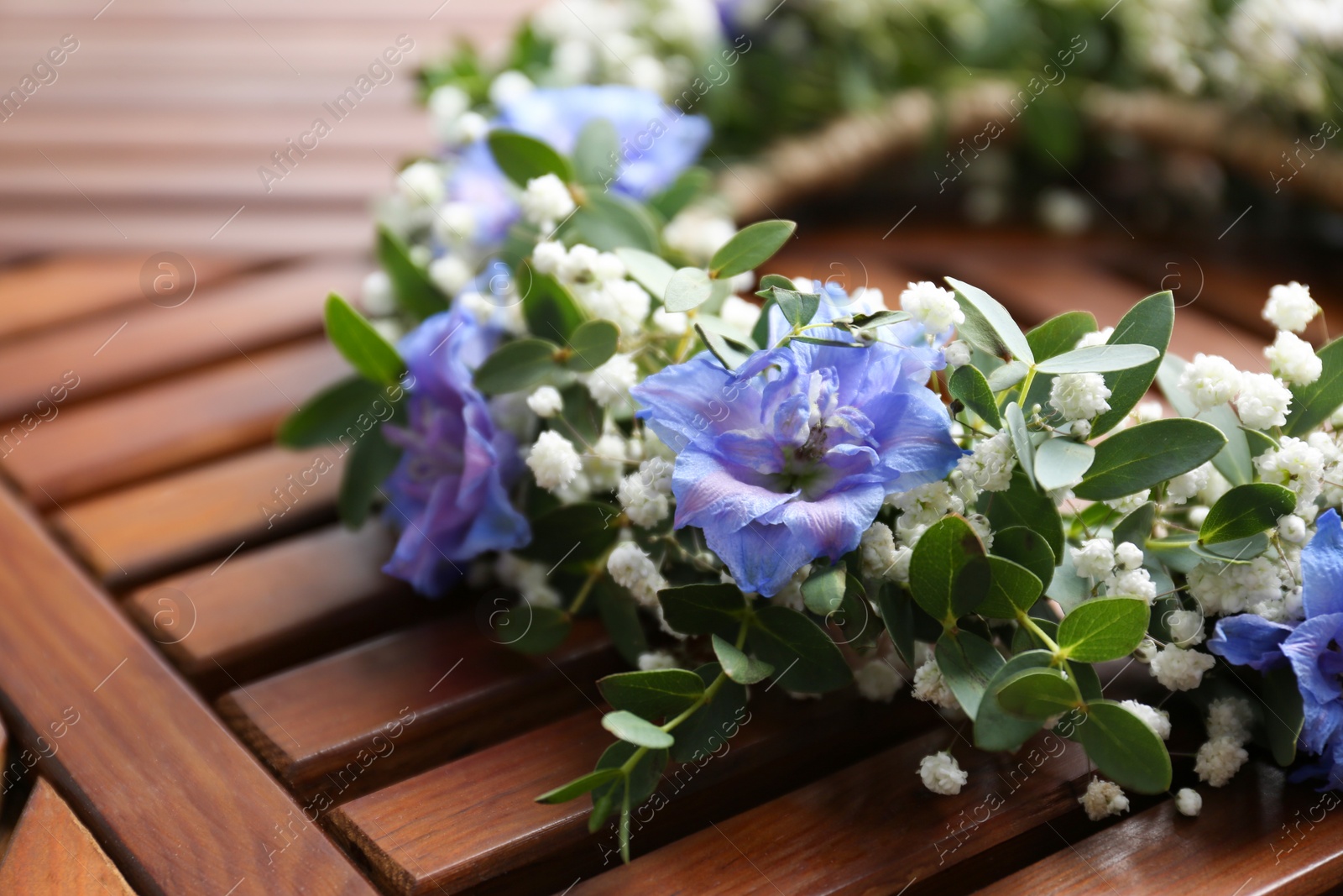 Photo of Beautiful flower wreath on wooden background, closeup