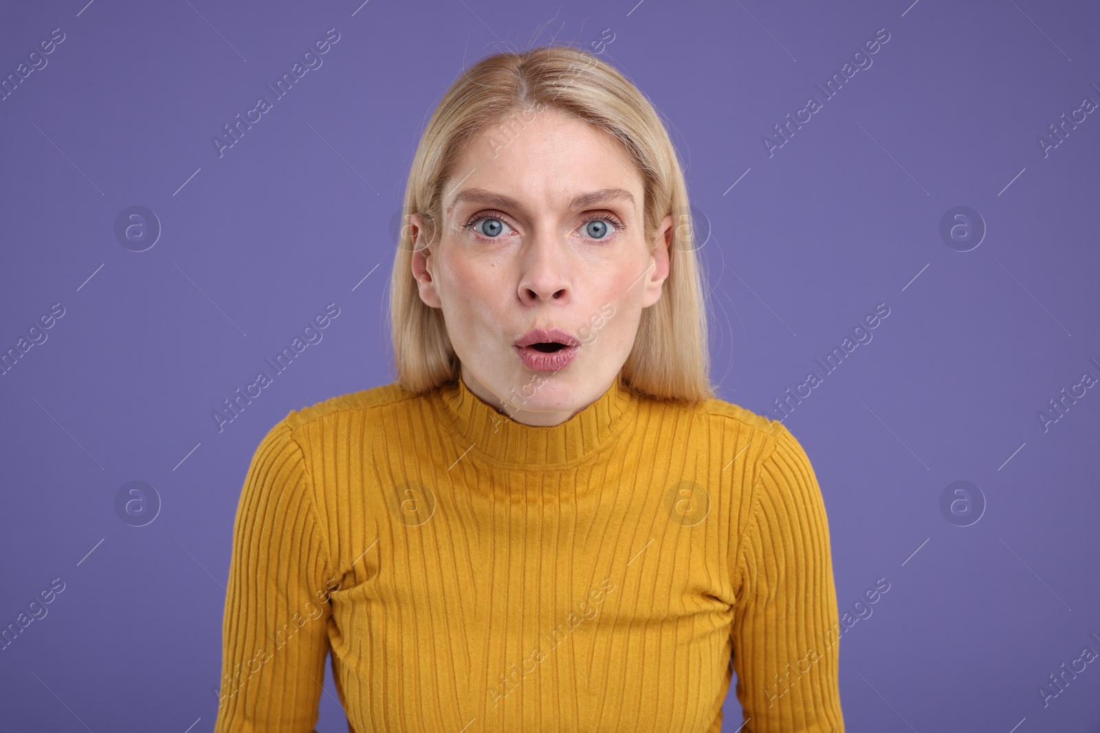 Photo of Portrait of surprised woman on violet background