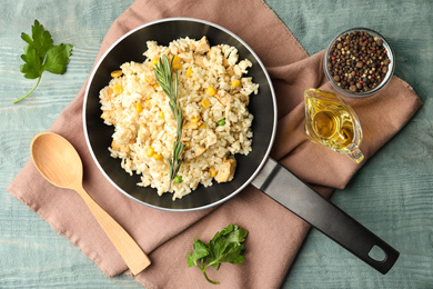 Photo of Delicious chicken risotto served on light blue wooden table, flat lay
