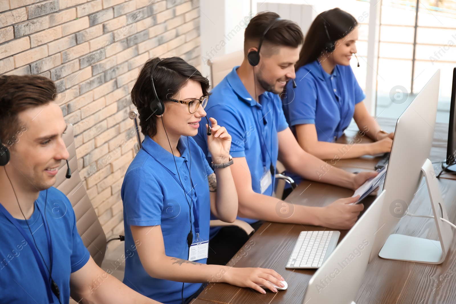 Photo of Technical support operators with headsets at workplace