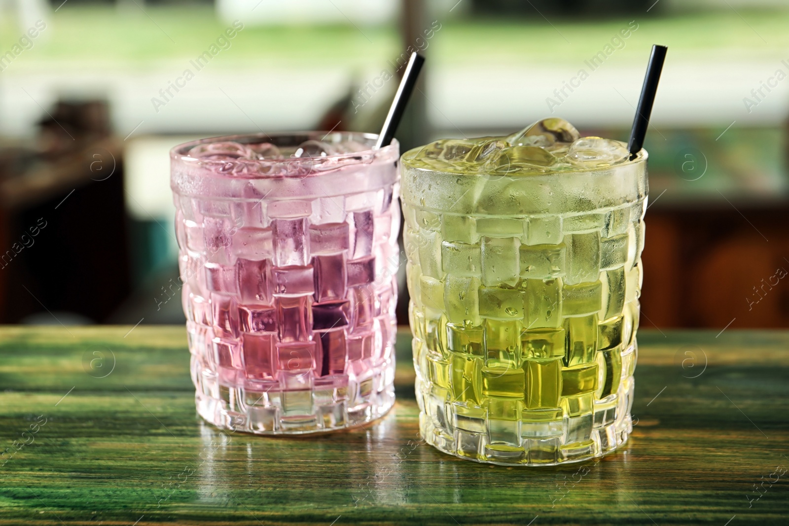 Photo of Glasses of delicious cocktails with ice on table