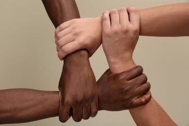 Photo of Men joining hands together on beige background, closeup