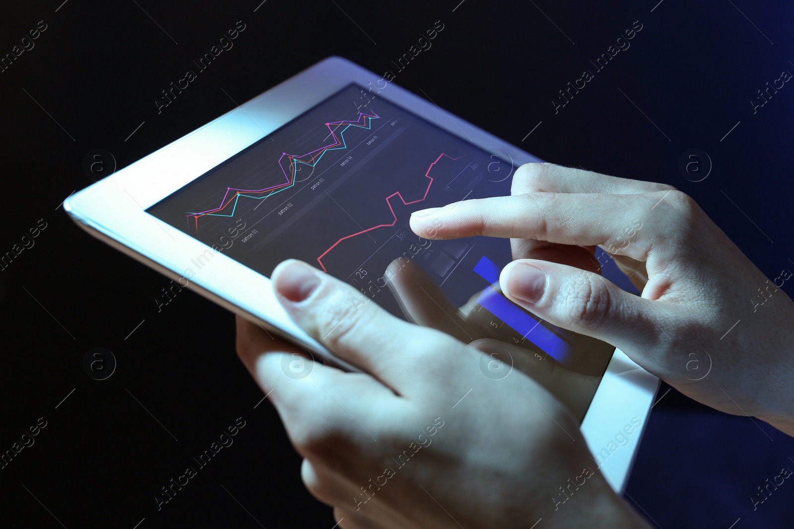 Image of Broker using tablet on dark background, closeup. Forex trading