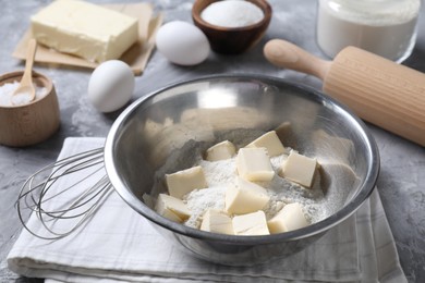 Making shortcrust pastry. Different ingredients for dough, whisk and rolling pin on grey table