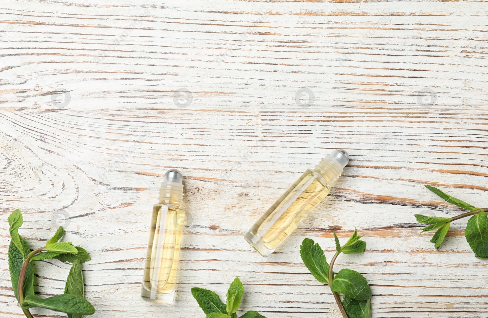 Photo of Flat lay composition with mint essential oil and space for text on white wooden background