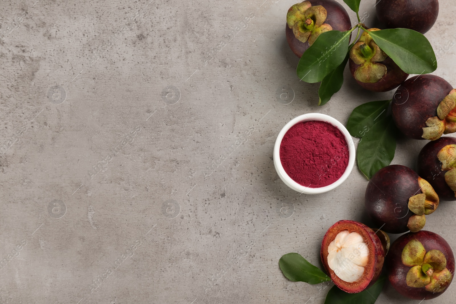 Photo of Purple mangosteen powder and fruits on light grey table, flat lay. Space for text