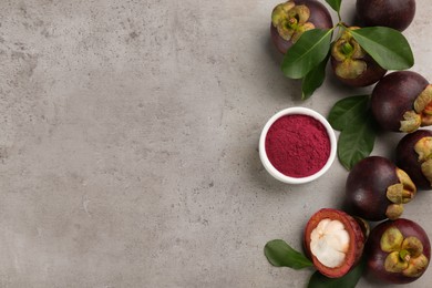 Purple mangosteen powder and fruits on light grey table, flat lay. Space for text