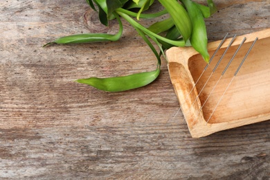 Flat lay composition with bamboo stick and acupuncture needles on wooden table