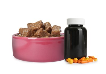 Image of Wet pet food in feeding bowl and bottle with vitamin pills on white background