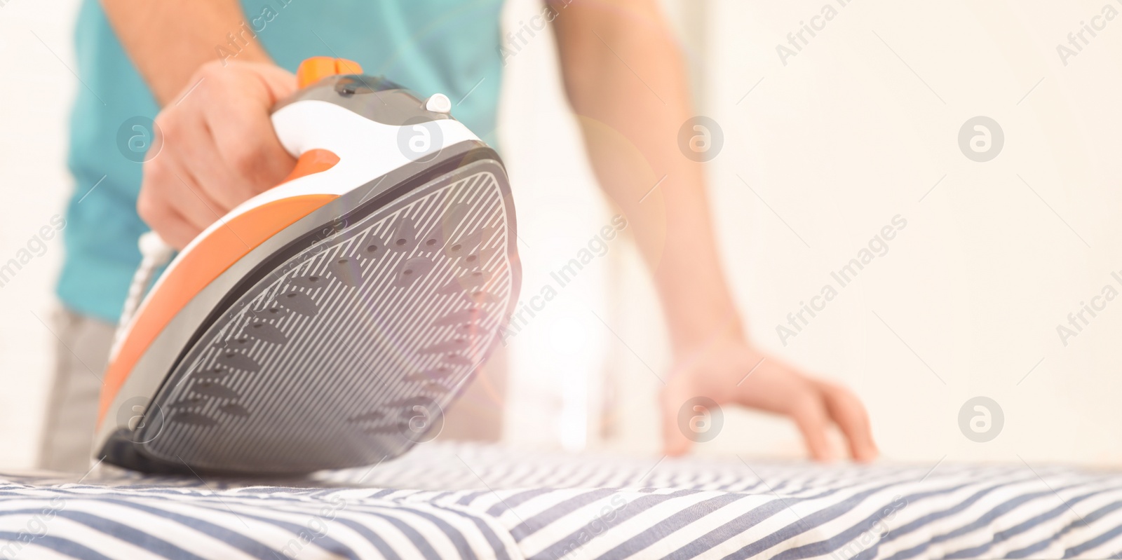 Image of Man ironing shirt on board at home, space for text. Banner design