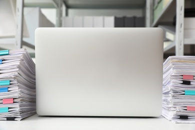 Photo of Laptop and documents on desk in office