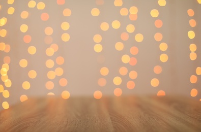 Photo of Empty wooden surface and blurred lights on background. Bokeh effect