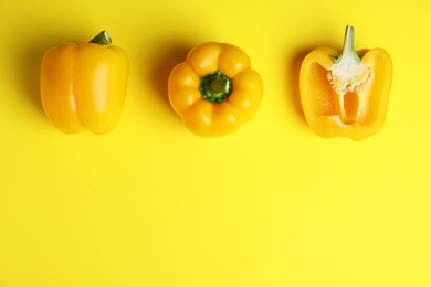 Ripe bell peppers on yellow background, flat lay. Space for text