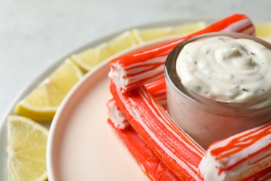 Crab sticks with sauce and lemon slices, closeup