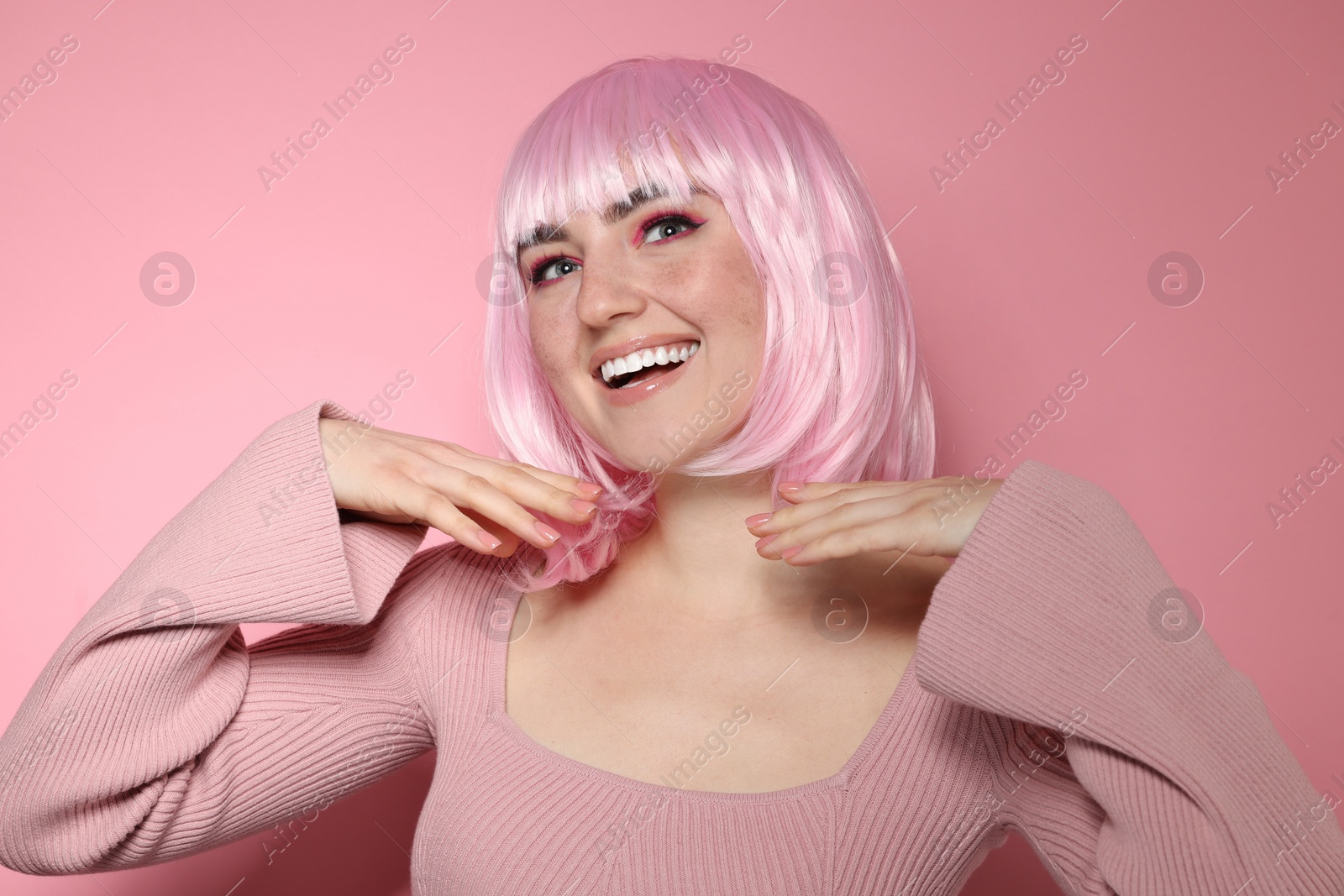 Photo of Happy woman with bright makeup and fake freckles on pink background