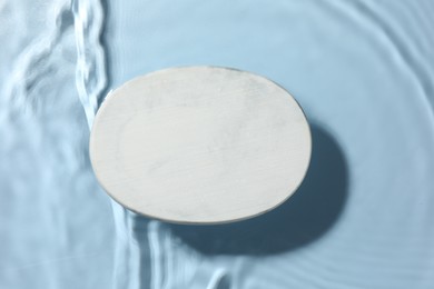 Photo of Presentation for product. White podium in water on light blue background, top view