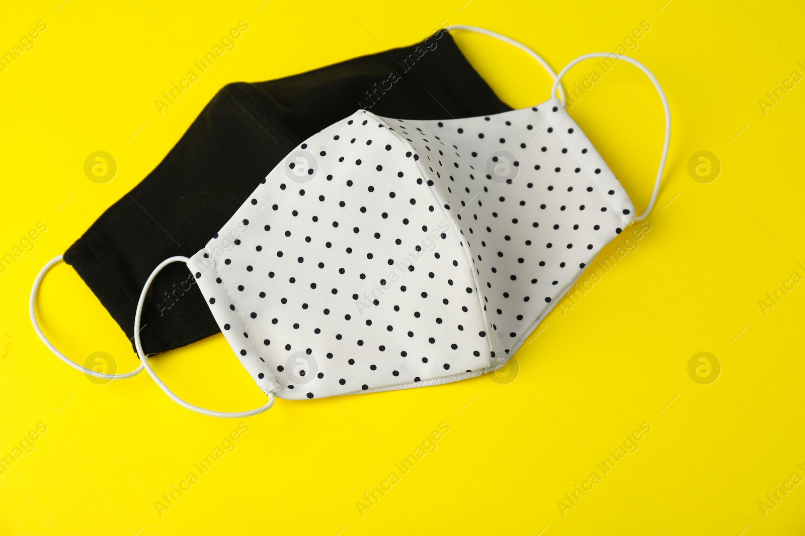 Photo of Homemade protective face masks on yellow background