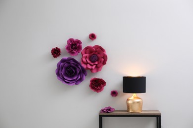 Night lamp on table near wall with floral decor