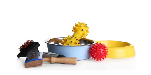 Photo of Feeding bowls, brushes and dog toys on white background