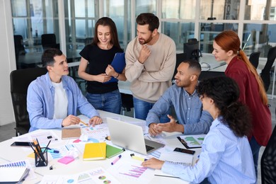 Photo of Team of employees working together at table in office. Startup project