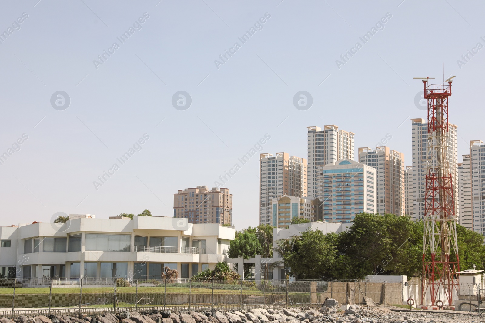 Photo of AJMAN, UNITED ARAB EMIRATES - NOVEMBER 04, 2018: Landscape with modern multi-storey buildings on sunny day