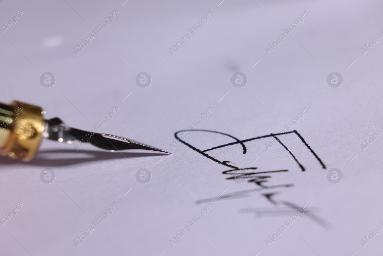 Photo of Fountain pen and signature on sheet of paper, closeup