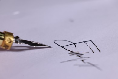 Photo of Fountain pen and signature on sheet of paper, closeup