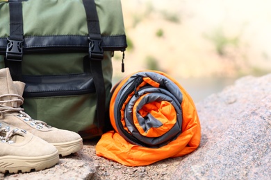 Photo of Backpack with sleeping bag and boots outdoors on sunny day