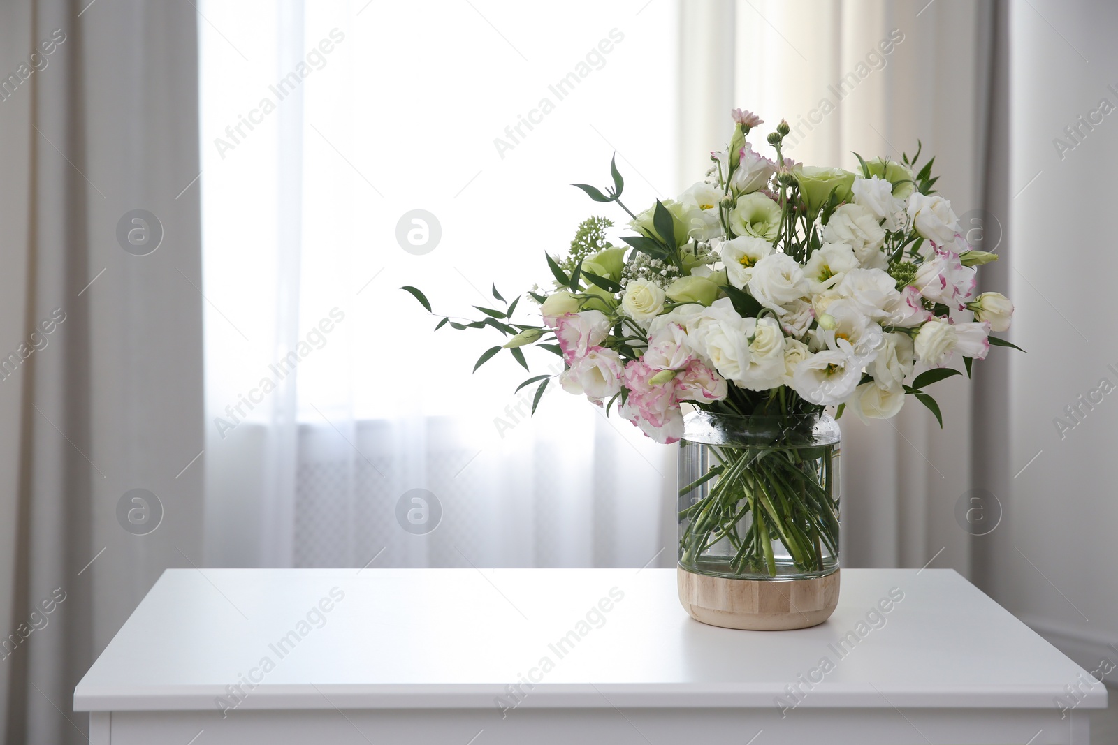 Photo of Bouquet of beautiful flowers on table in room, space for text. Interior design