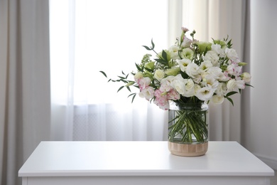 Bouquet of beautiful flowers on table in room, space for text. Interior design